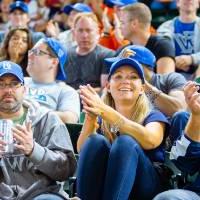 Large group of people with Grand Valley clothes on cheering in the stands